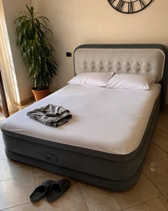 Materasso gonfiabile pronto in soggiorno con piante e orologio a muro
