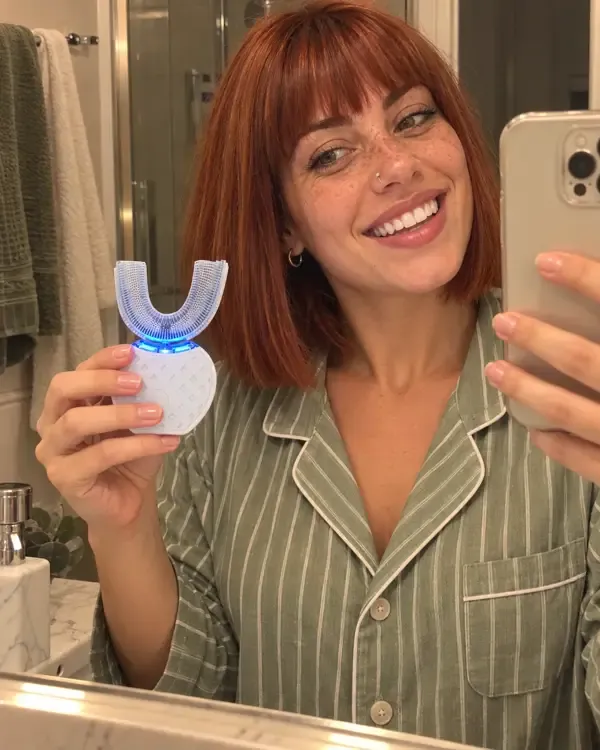 Giulia la sera in pigiama, sorridente, con lo spazzolino a U in mano prima di andare a letto