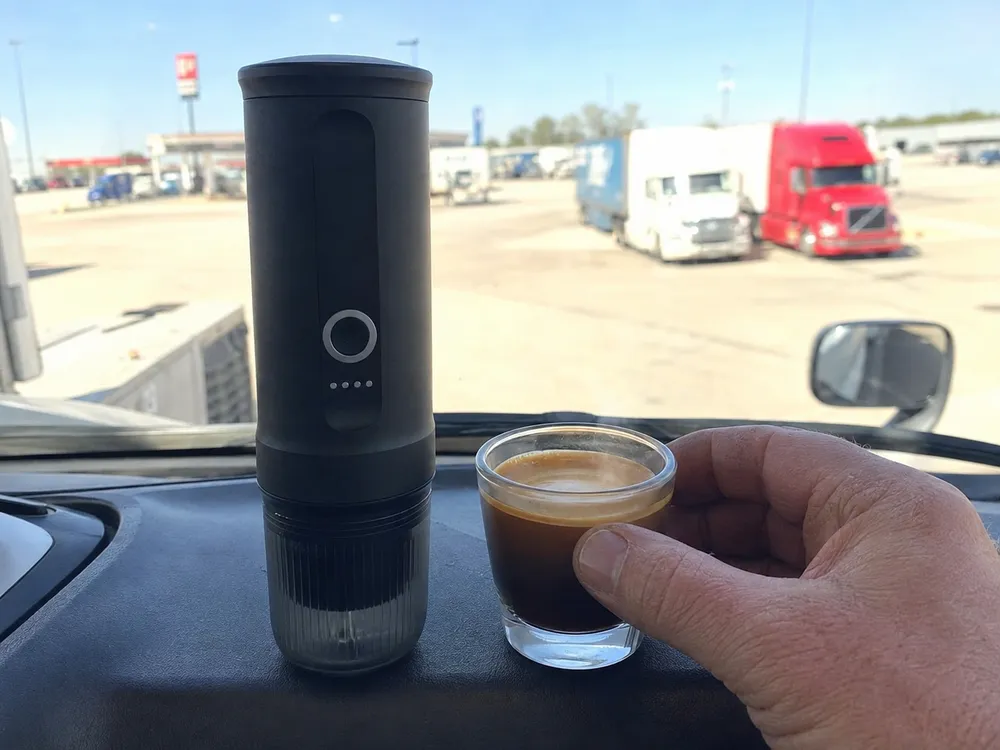 Macchina espresso portatile sul cruscotto del camion in un'area di sosta