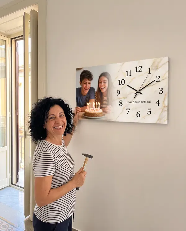 Mamma che ha appena appeso l'orologio con la foto dei figli